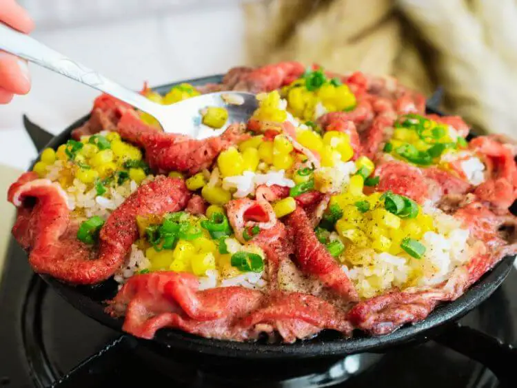 The image shows a close-up of a plate of food with a spoon