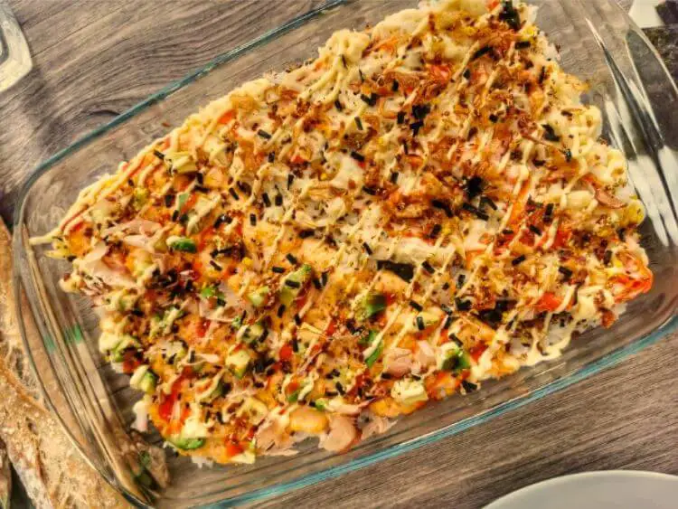 image shows a casserole dish filled with pasta, cheese, and vegetables