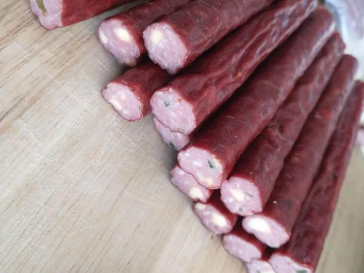 a bunch of meat sticks sitting on top of a wooden table