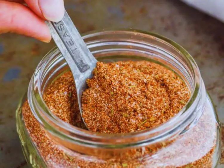 image shows a clear glass jar filled with a spoonful of seasoning