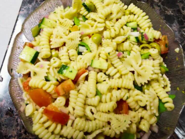 The image shows a close-up of a pasta salad in a bowl.