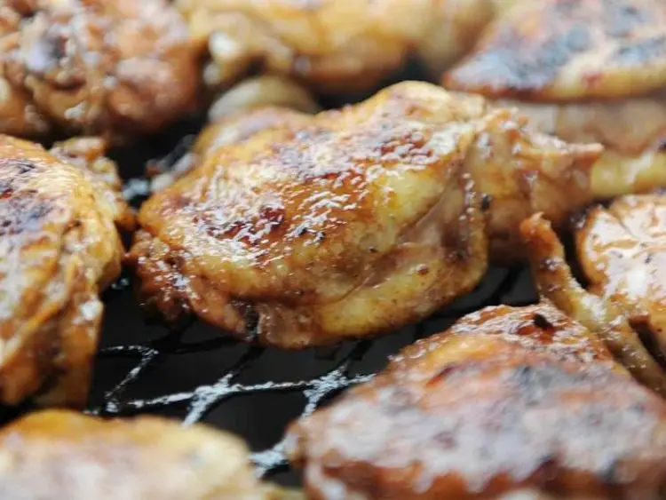 a close-up of several pieces of chicken being grilled.