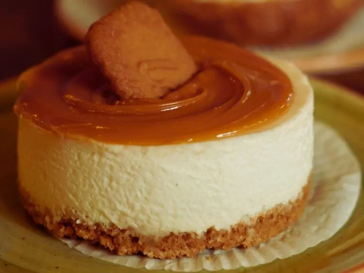a single round cheesecake with a smooth, creamy filling and a golden-brown crust at the bottom. It appears to be topped with a glossy caramel sauce that has been artfully swirled on top.